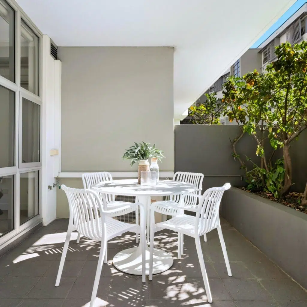 Milo Indoor/Outdoor Dining Chairs arranged around a table on an open terrace, with natural light, greenery, and a relaxed modern atmosphere highlighting their sleek, weather-resistant design.