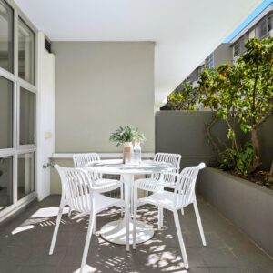 Milo Indoor/Outdoor Dining Chairs arranged around a table on an open terrace, with natural light, greenery, and a relaxed modern atmosphere highlighting their sleek, weather-resistant design.