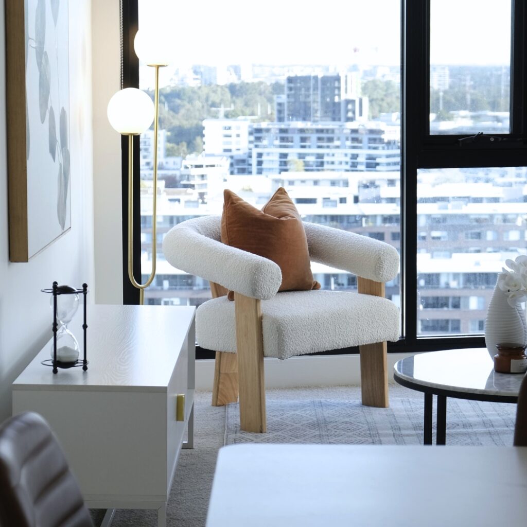 Boucle and Wood Curved Armchair - White & Natural placed in the living room