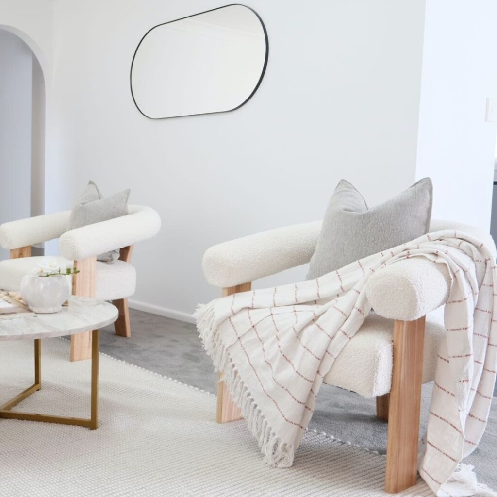 Boucle and Wood Curved Armchair - White & Natural placed in the living room