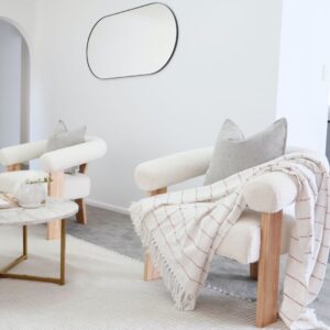 Boucle and Wood Curved Armchair - White & Natural placed in the living room