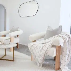 Boucle and Wood Curved Armchair - White & Natural placed in the living room
