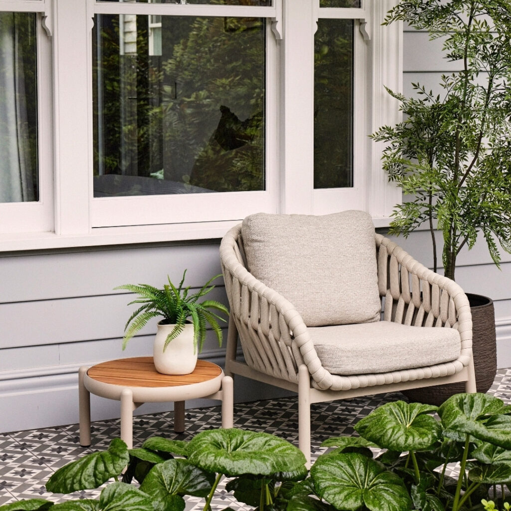 Elwood Outdoor Coffee Table placed beside outdoor armchairs