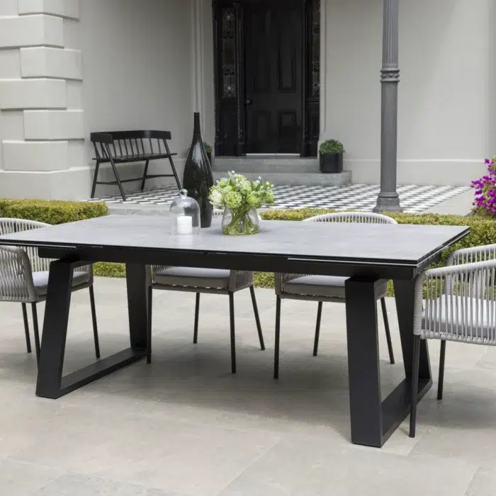 Baluga extension dining table with andesite ceramic top and powder-coated steel frame for indoor outdoor use
