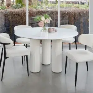 White round dining table with marble-inspired ceramic top and sculpted column bases