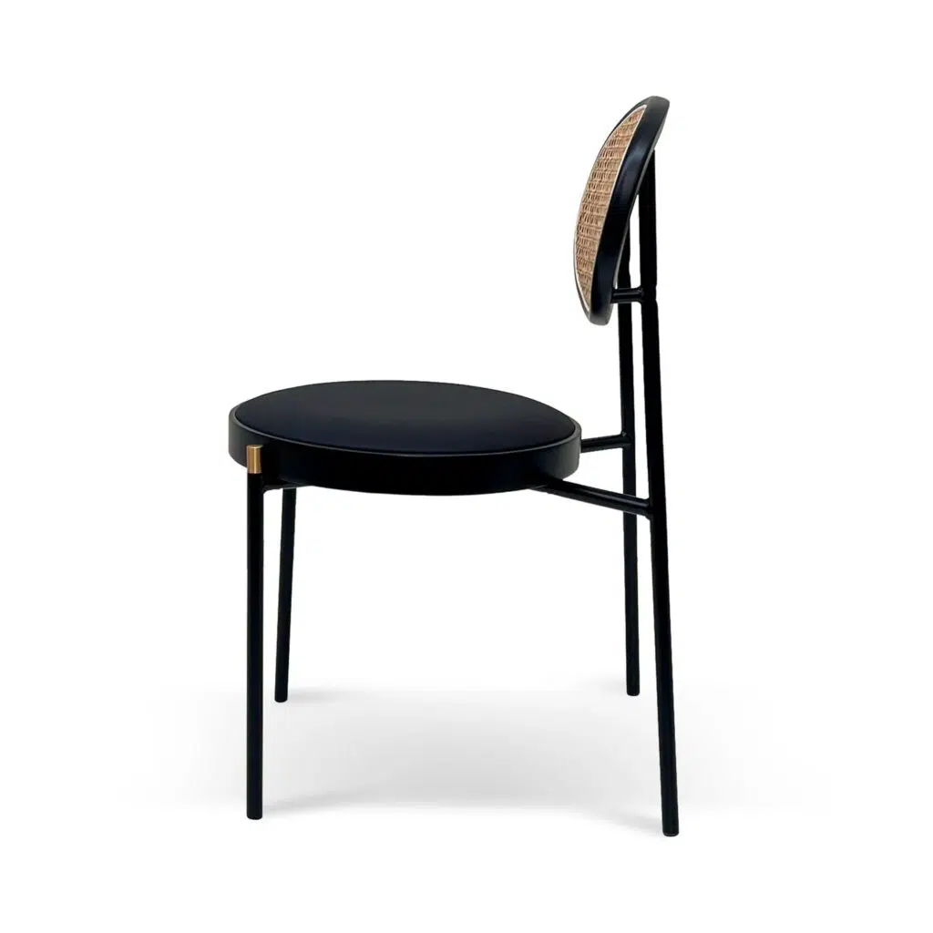 Black dining chair with gold accents and natural rattan backrest for modern interiors