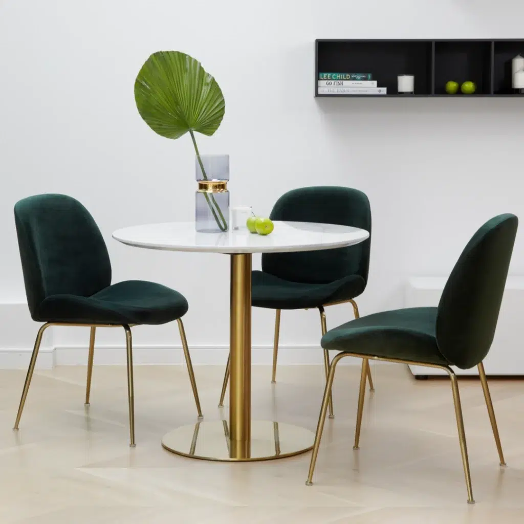 Elegant emerald dining chairs with velvet upholstery and golden metal legs for modern spaces