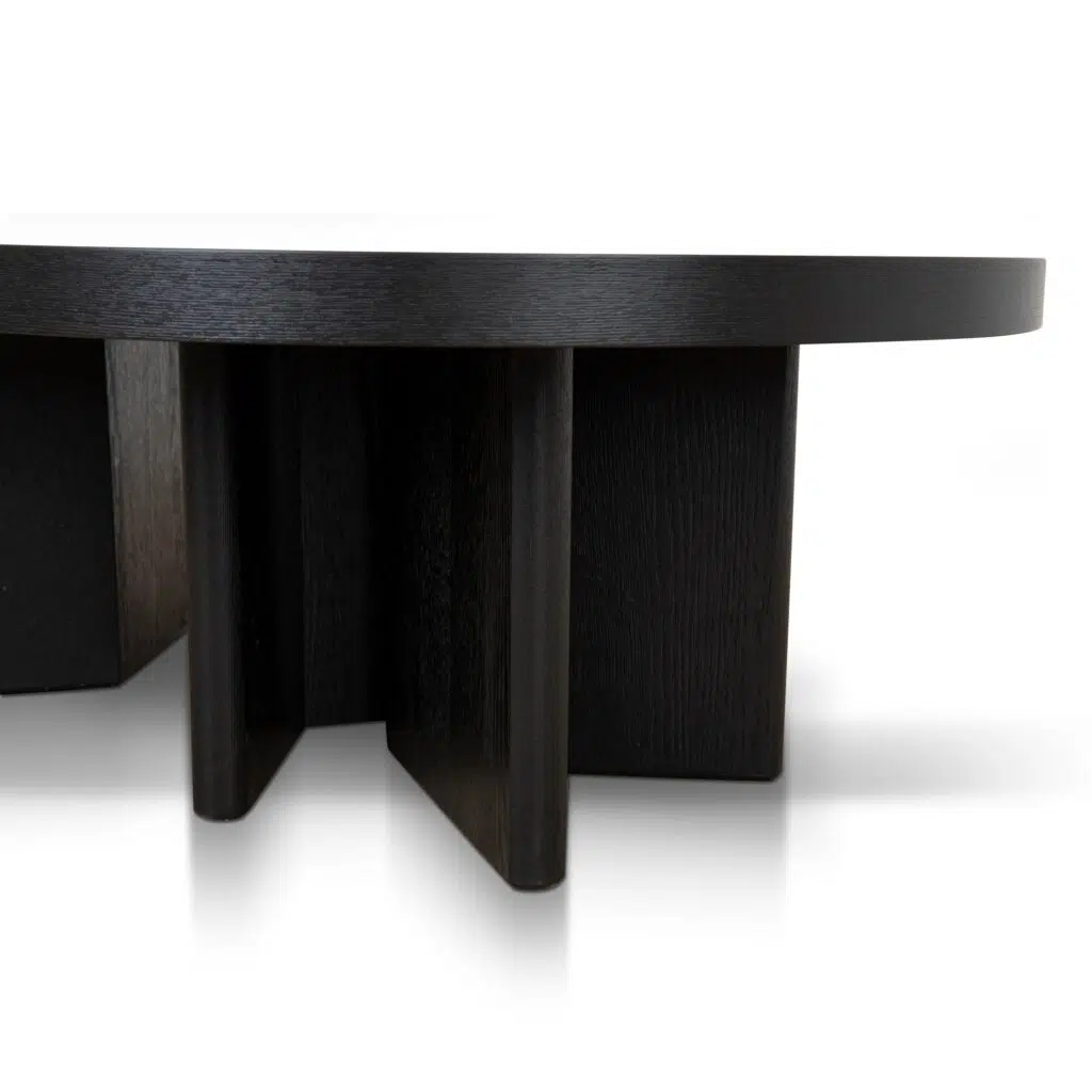 Modern pill-shaped coffee table with textured espresso black finish and geometric legs.
